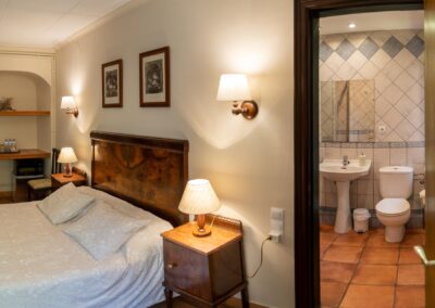 Habitación «La Guineu». Detalle de la cama de matrimonio y del lavabo. Casa de turismo rural Can Rosich, Santa Susanna, Barcelona
